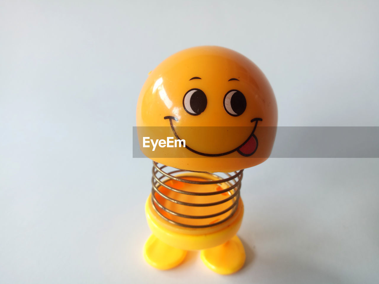 CLOSE-UP OF YELLOW TOY AGAINST WHITE BACKGROUND