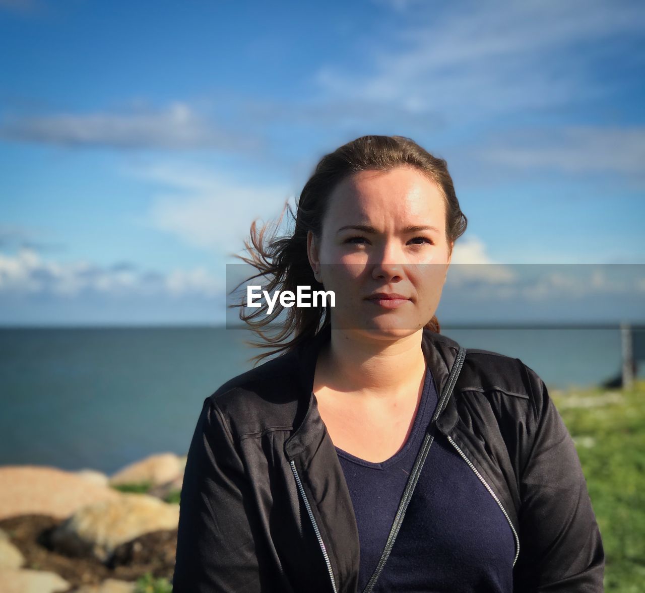 Portrait of woman against sea in sunny day