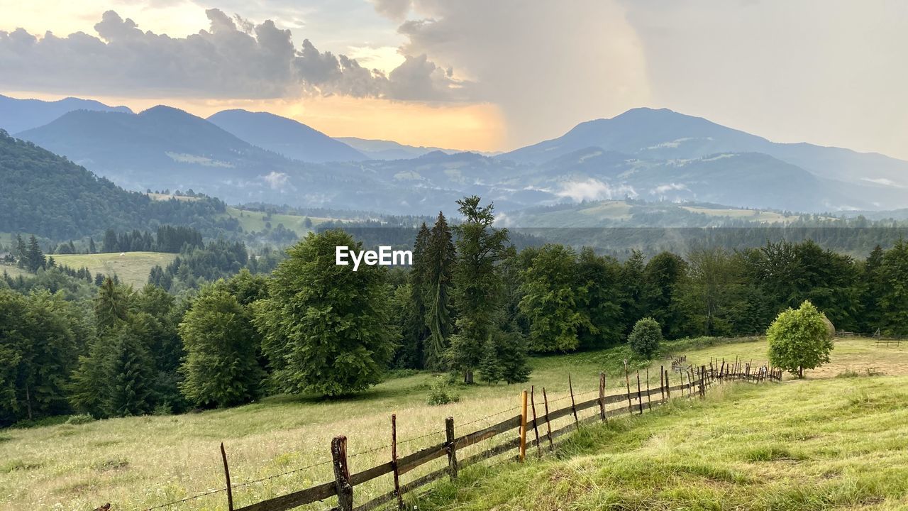 Scenic view of field and mountains against sky