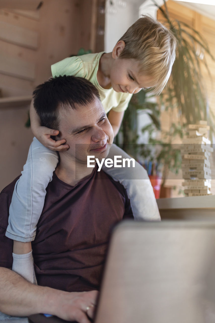 side view of boy using laptop while sitting at home