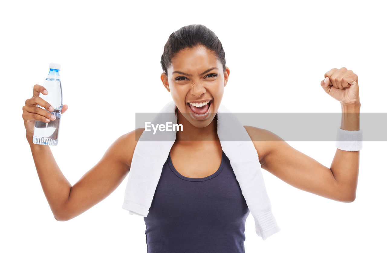 white background, smiling, finger, happiness, cut out, adult, one person, women, emotion, portrait, studio shot, cheerful, lifestyles, young adult, vitality, looking at camera, female, arm, indoors, person, positive emotion, communication, front view, human limb, waist up, muscular build, hand, limb, smile, relaxation, teeth, holding, joy, excitement, physical fitness, exercising, sports, strength, gesturing, technology, success, arms raised, bottle, flexing muscles, casual clothing, wellbeing, fun, athlete, enjoyment, clothing