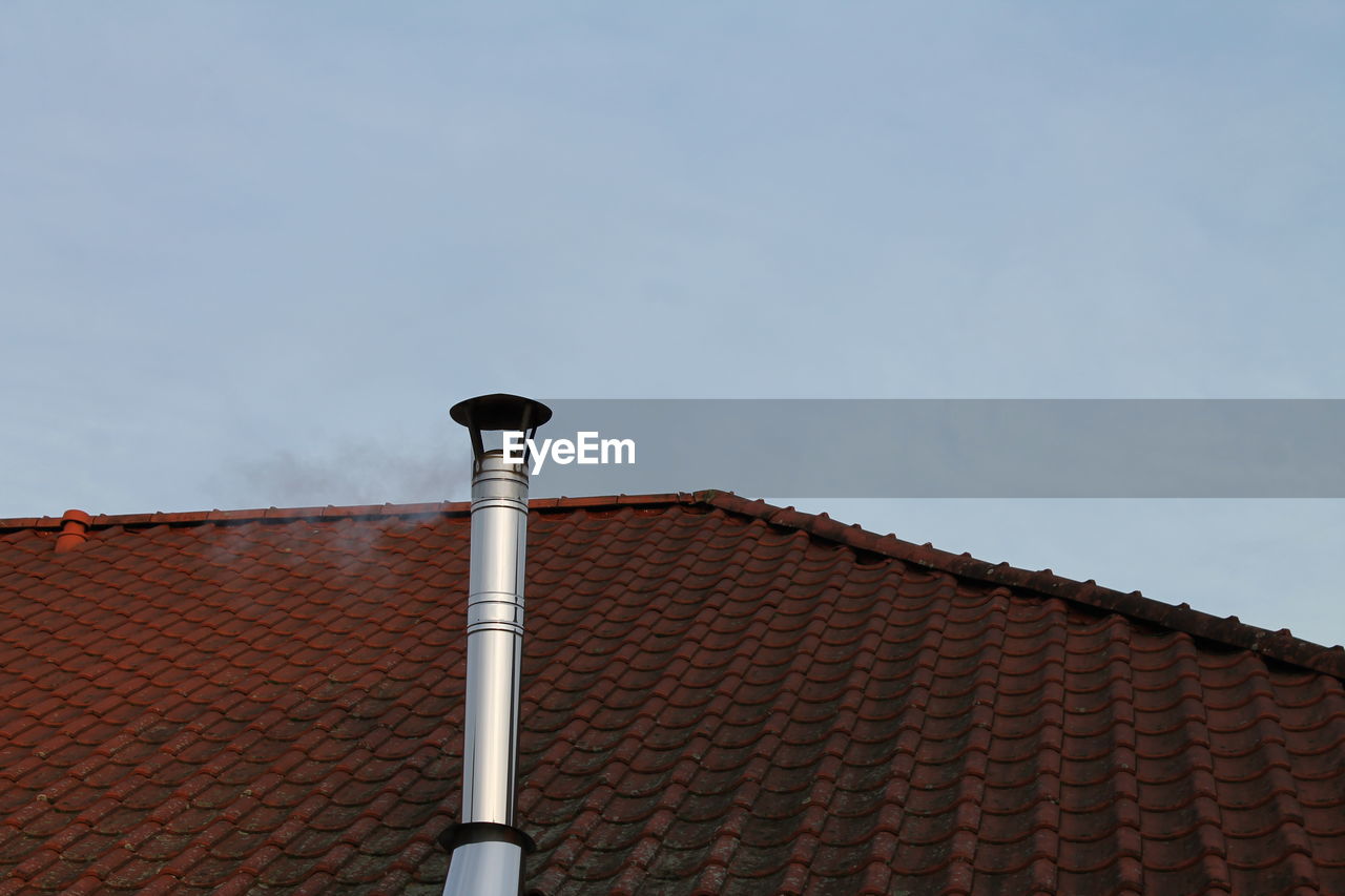 Chimney on rooftop against sky