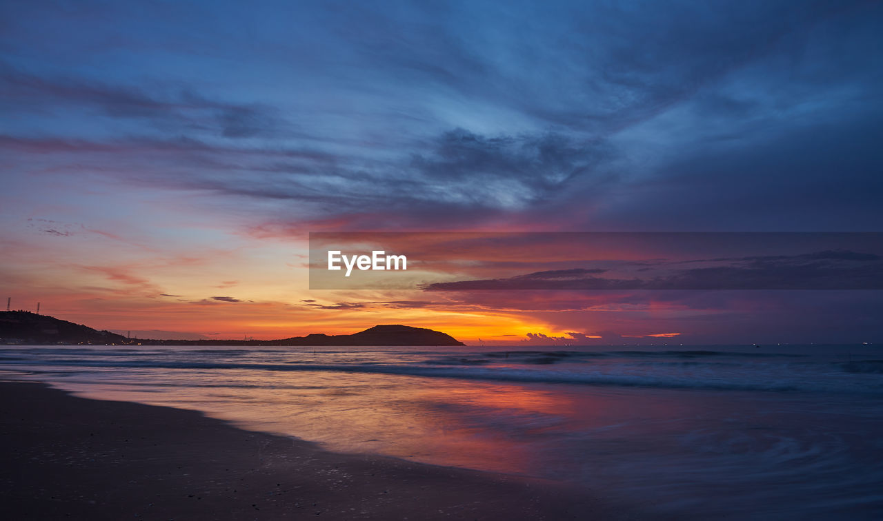 scenic view of sea against cloudy sky during sunset
