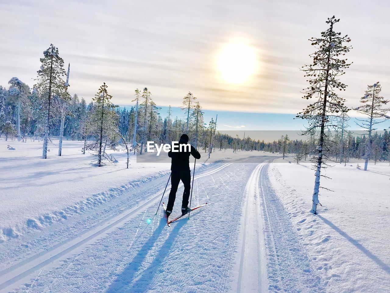 Rear view of man skiing on snowy field