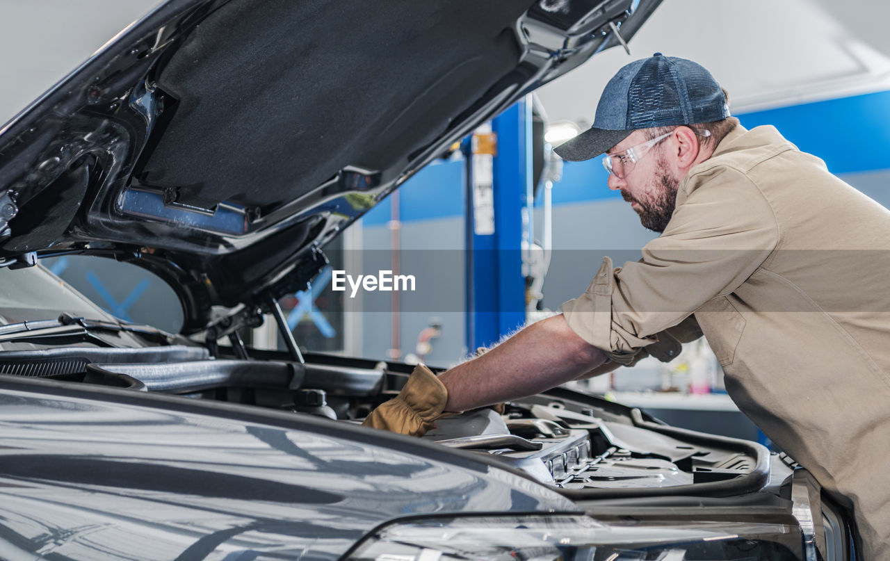 side view of man working on car