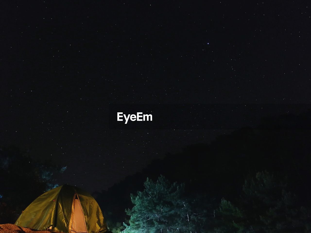 Low angle view of illuminated tent against sky at night