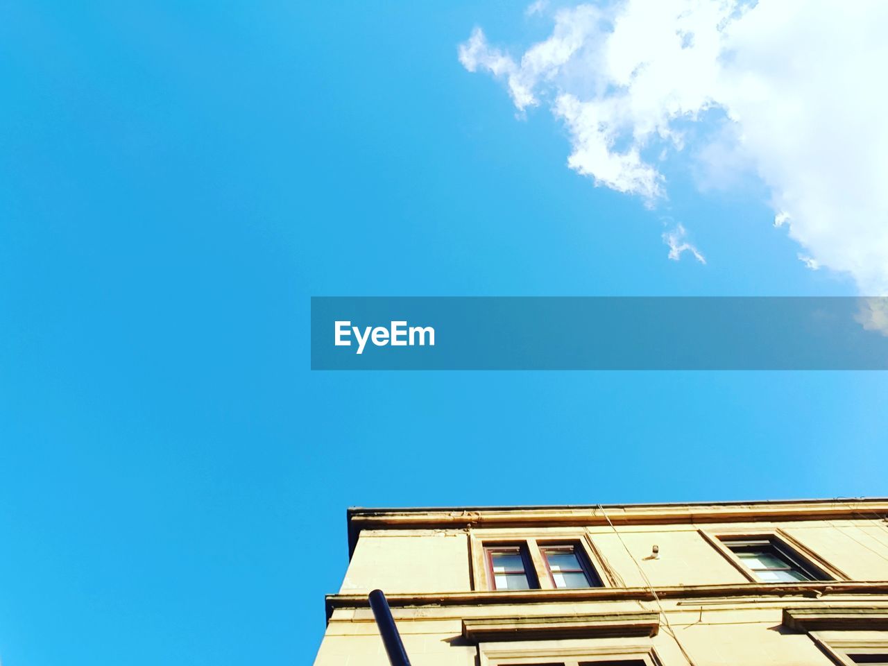 LOW ANGLE VIEW OF BUILDING AGAINST CLEAR BLUE SKY