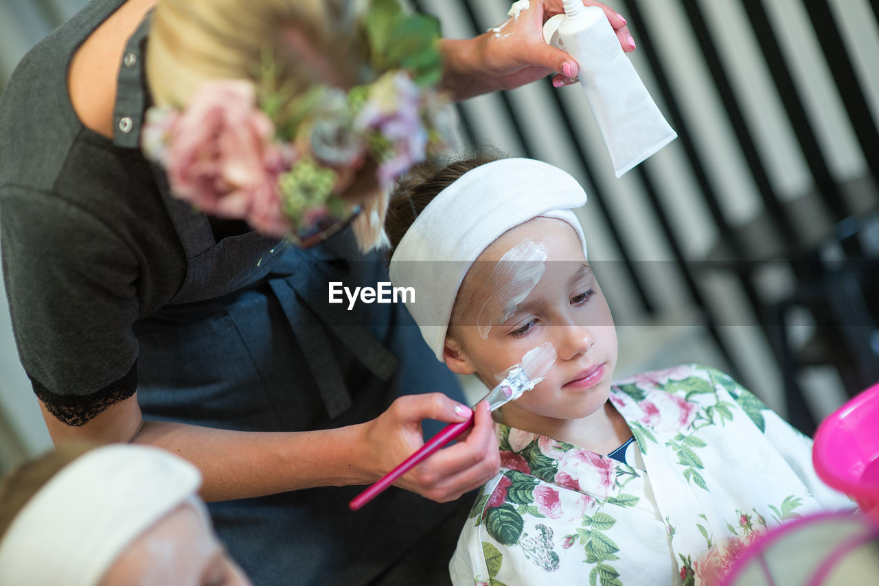 Beautician with girl at spa