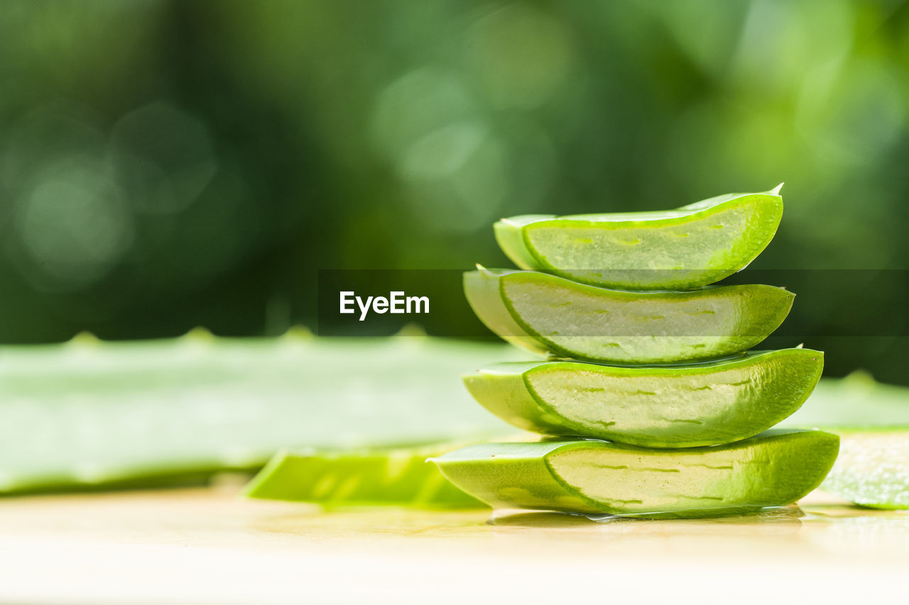 CLOSE-UP OF FRESH GREEN LEMON ON TABLE