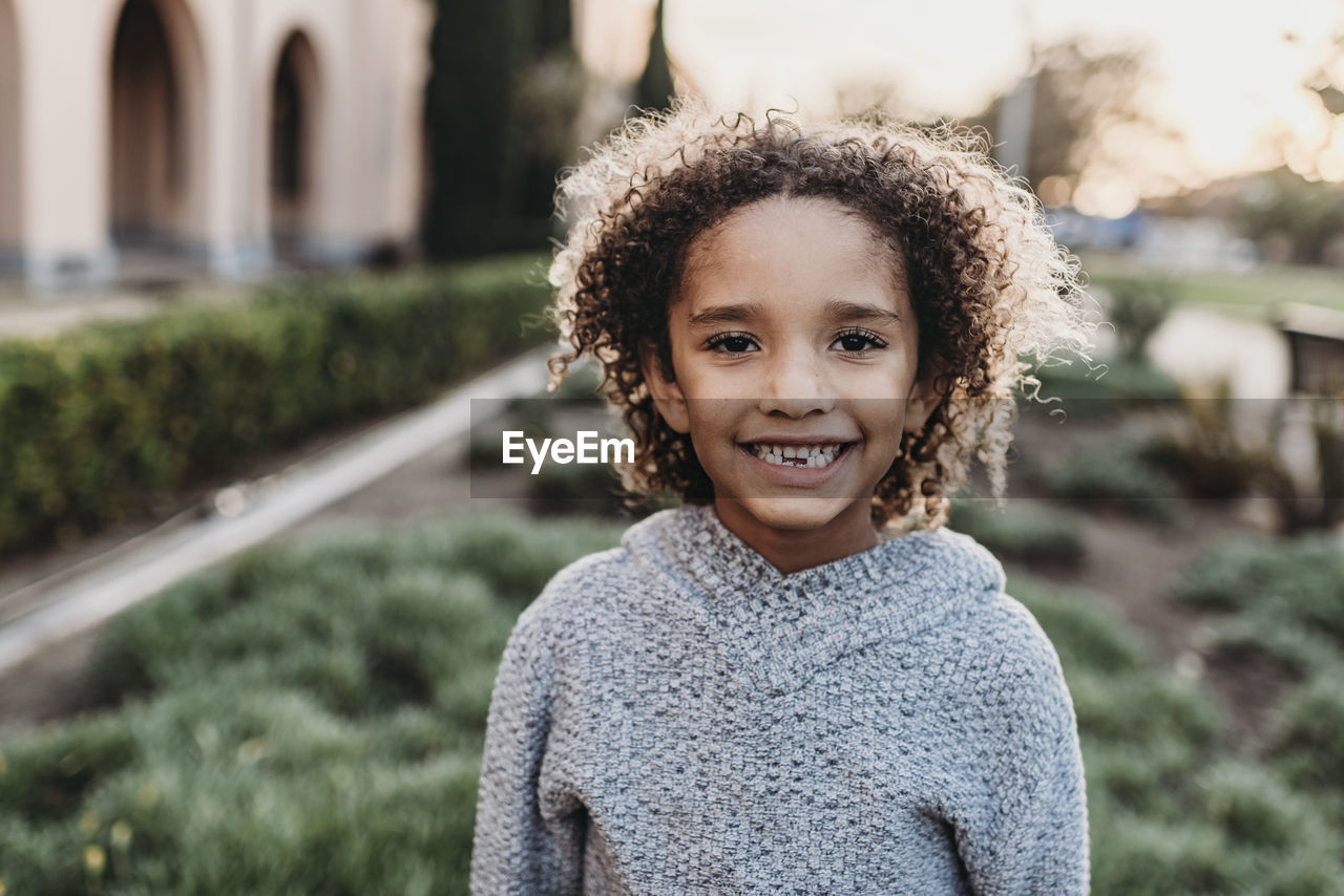 Close up portrait of young school-aged confident boy smiling at