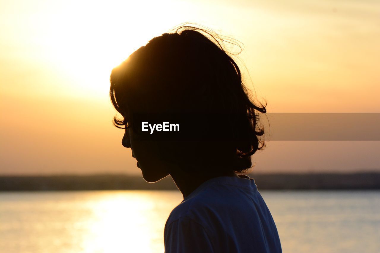 Portrait of boy against sea during sunset