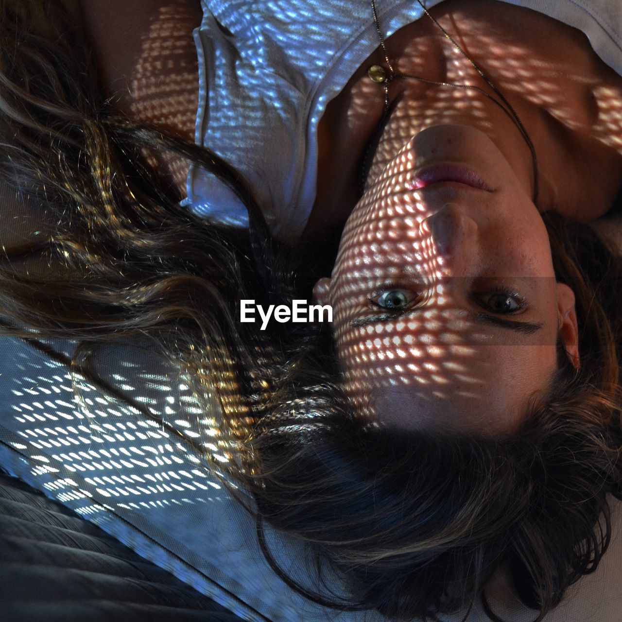 Upside down portrait image of young woman lying on wooden floor