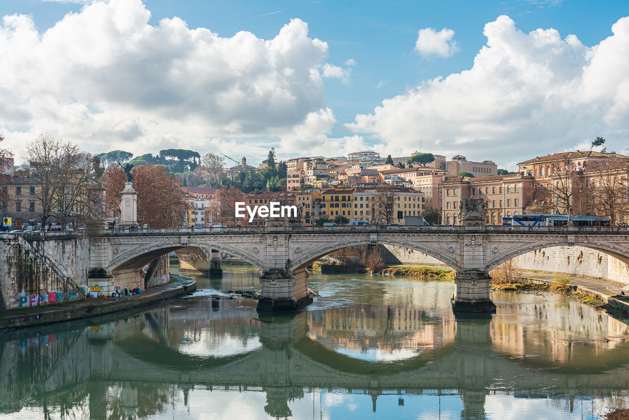 BRIDGE OVER RIVER AGAINST BUILDINGS IN CITY