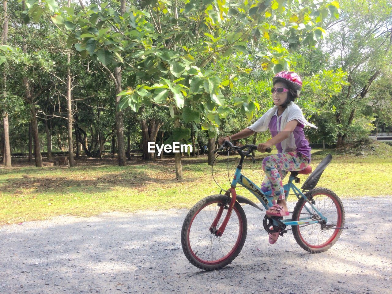 WOMAN RIDING BICYCLE ON PINK ROAD