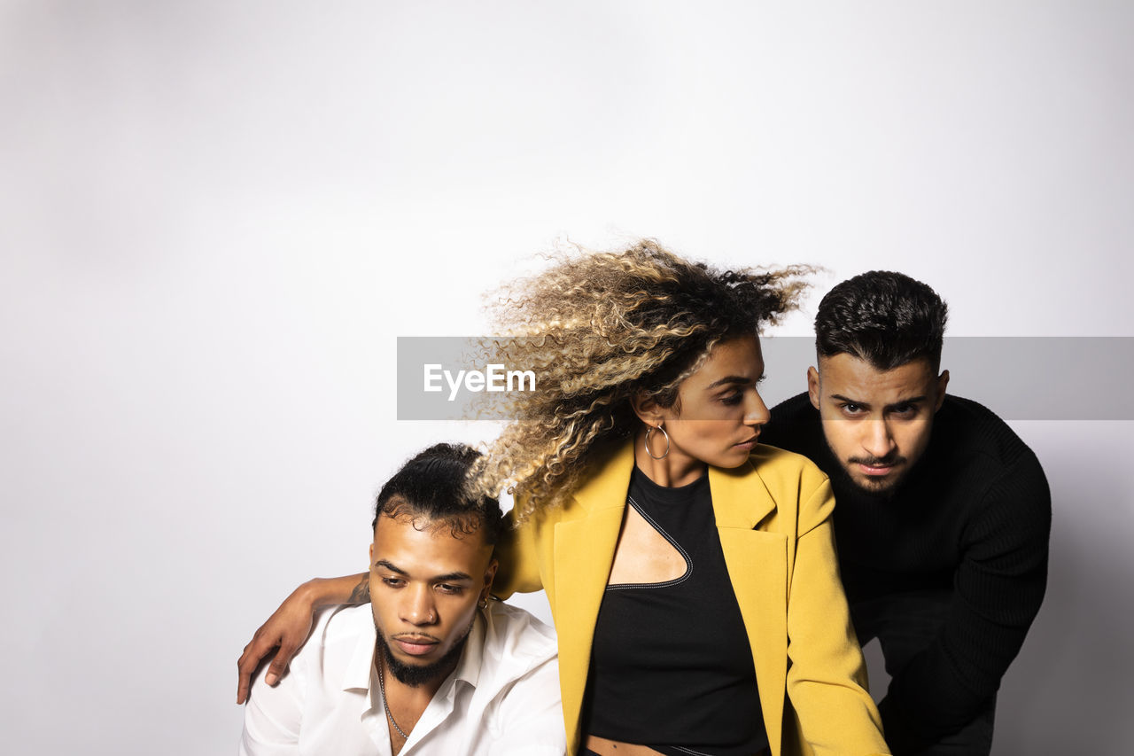 Portrait of young men and woman against white background