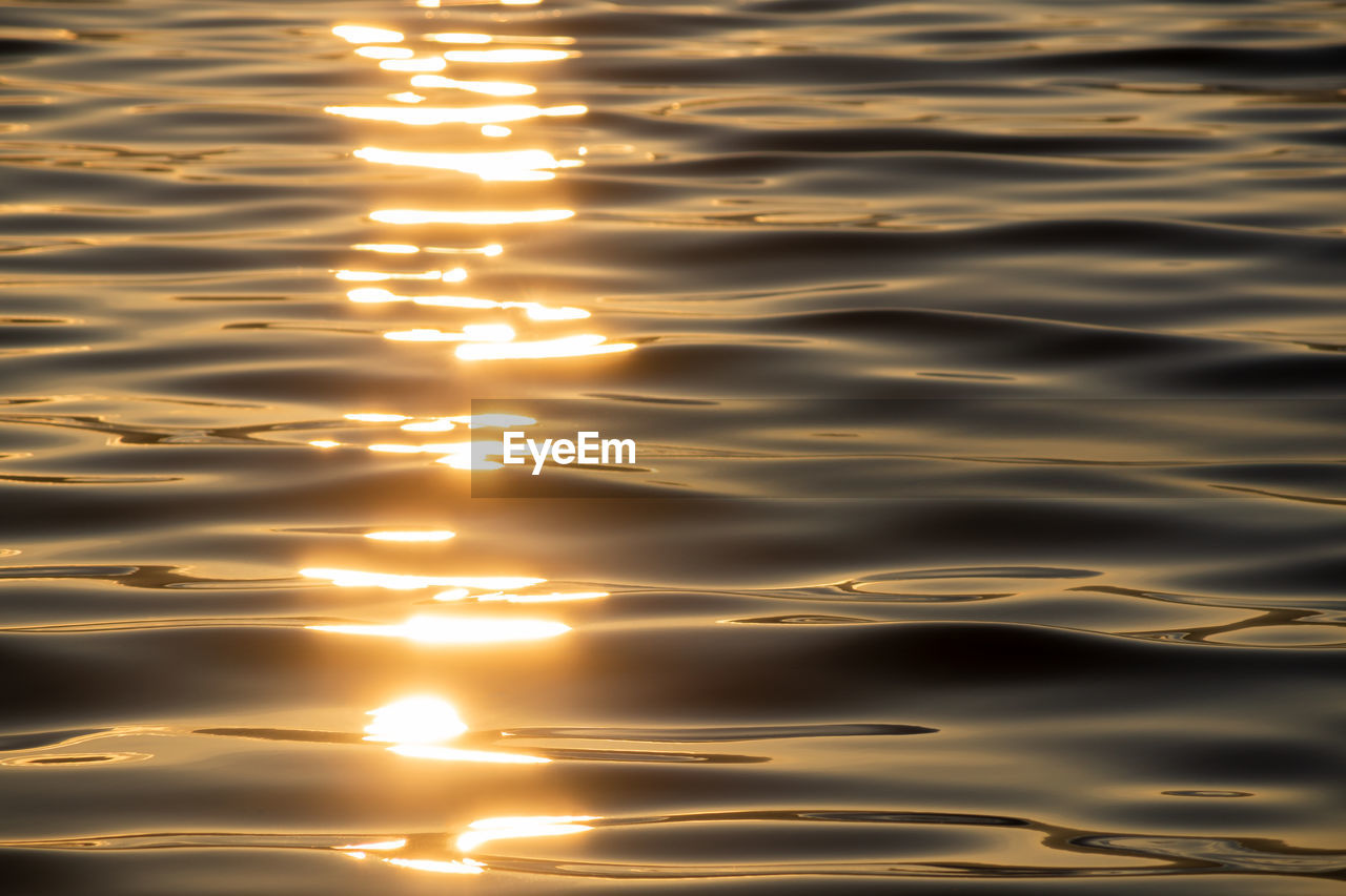 reflection, sunlight, sunset, water, light, nature, beauty in nature, no people, rippled, wave, backgrounds, sky, tranquility, full frame, sun, outdoors, scenics - nature, sea, shiny, orange color, pattern, tranquil scene, motion, yellow, idyllic