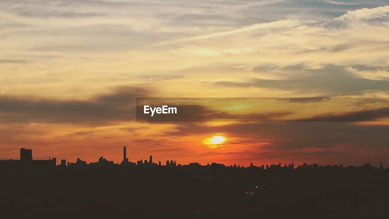 Silhouette cityscape against sky during sunset