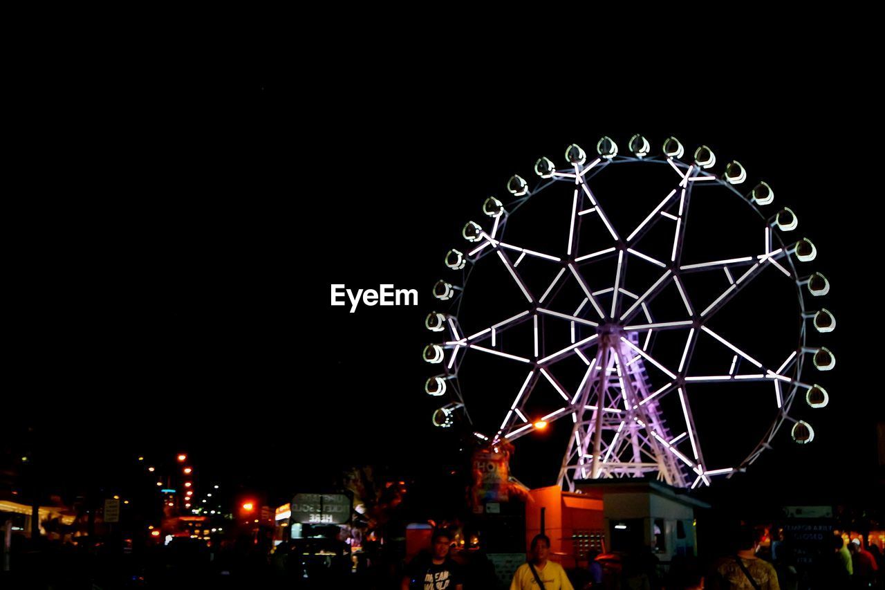 LOW ANGLE VIEW OF FERRIS WHEEL AT NIGHT