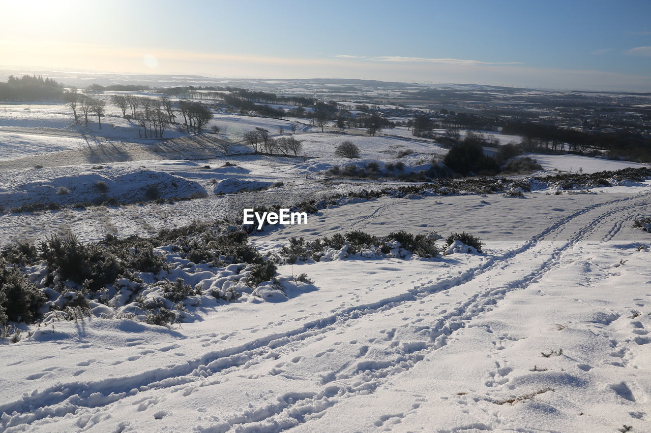 AERIAL VIEW OF SNOW COVERED LAND