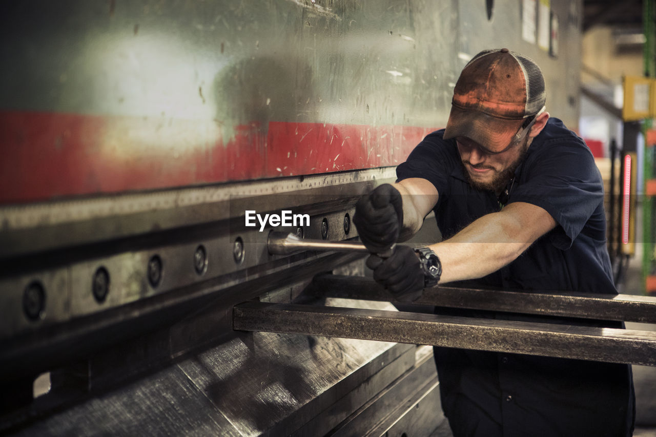 Manual worker using t wrench in metal industry