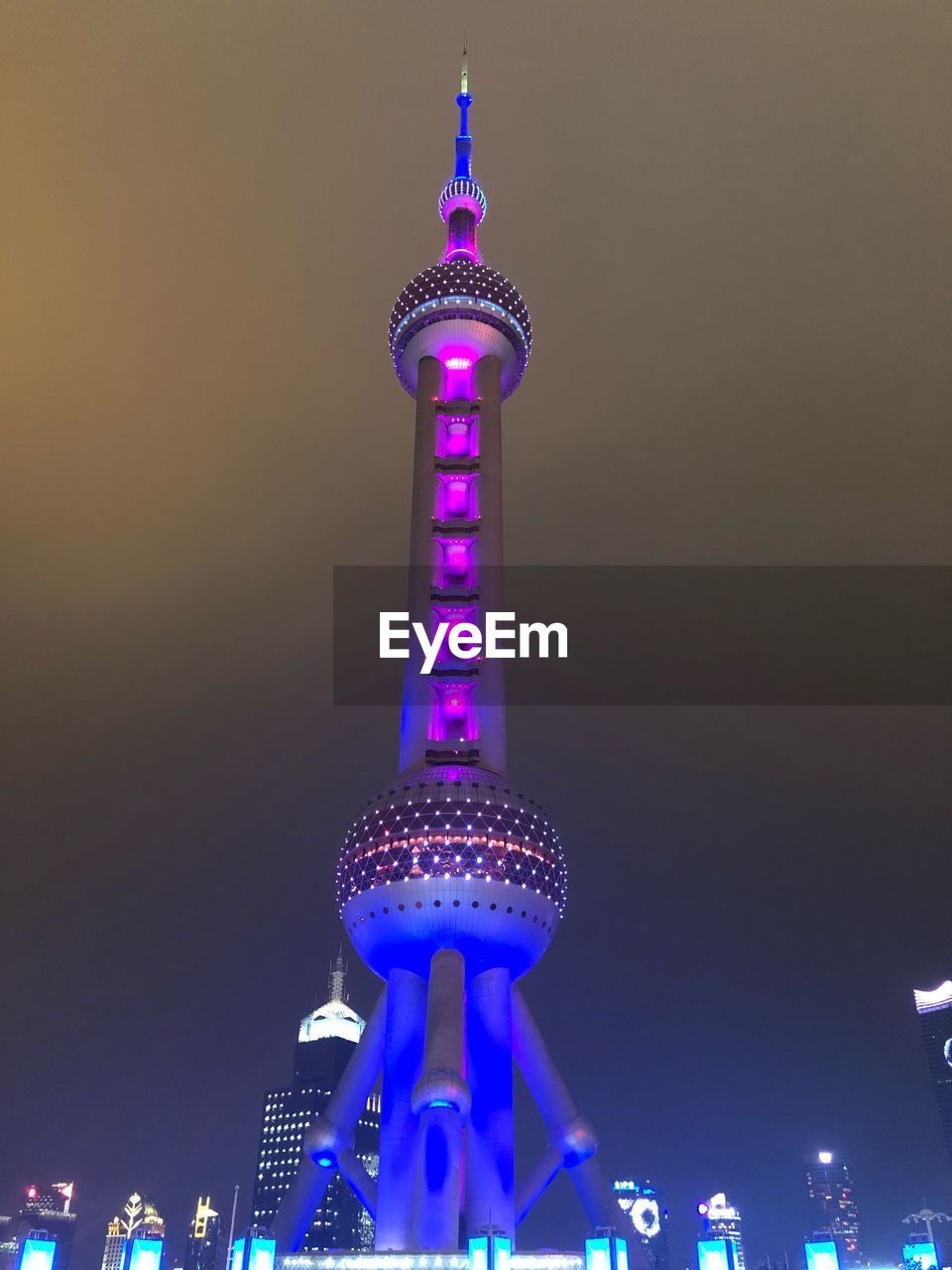 LOW ANGLE VIEW OF ILLUMINATED BUILDINGS AT NIGHT