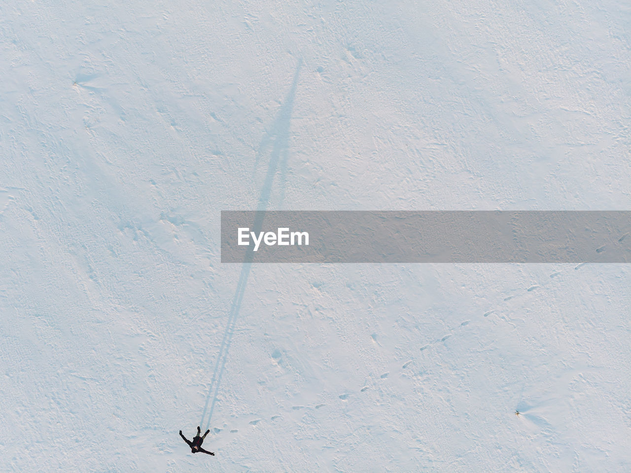 High angle view of mid adult man standing on snow covered field