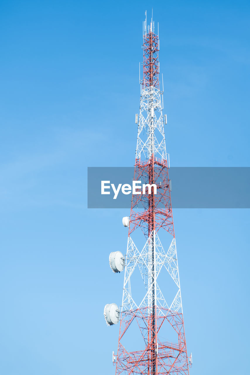 Low angle view of communications tower against clear blue sky