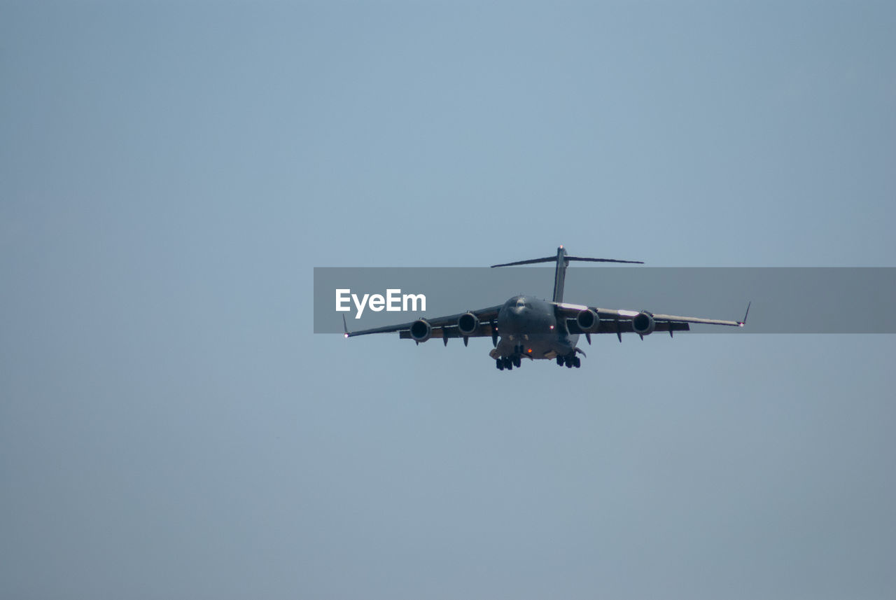 Low angle view of c17 airplane flying against clear sky