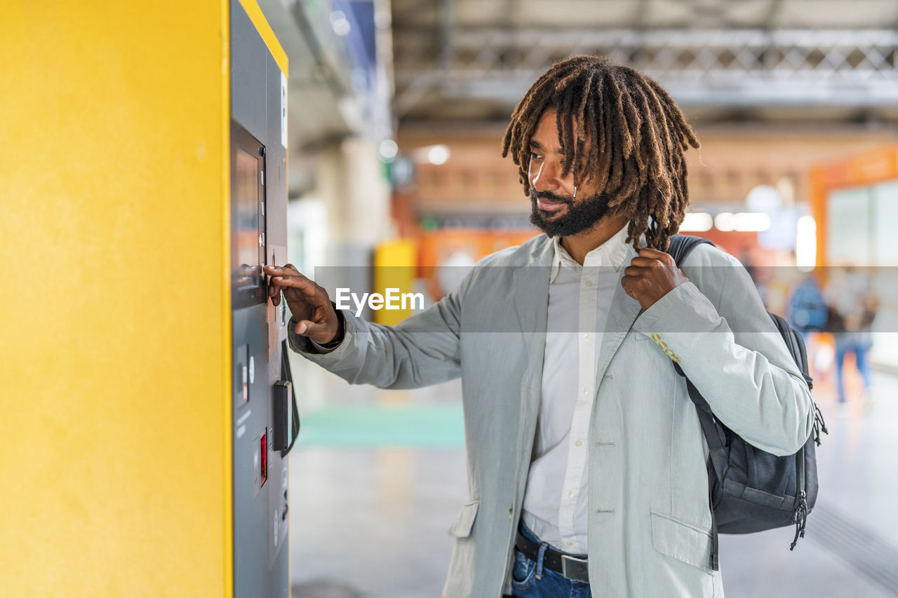 Smiling businessman using touch screen device at station