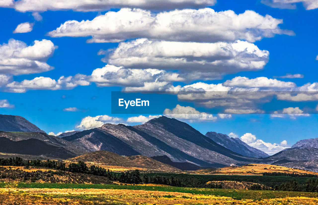 mountain, landscape, environment, sky, scenics - nature, cloud, beauty in nature, nature, mountain range, land, travel destinations, snow, no people, travel, grassland, snowcapped mountain, plateau, tranquil scene, tranquility, meadow, plant, cold temperature, non-urban scene, wilderness, outdoors, rural scene, blue, tourism, winter, valley, mountain peak, horizon, day, plain, field, idyllic, grass, prairie, rural area, flower, agriculture