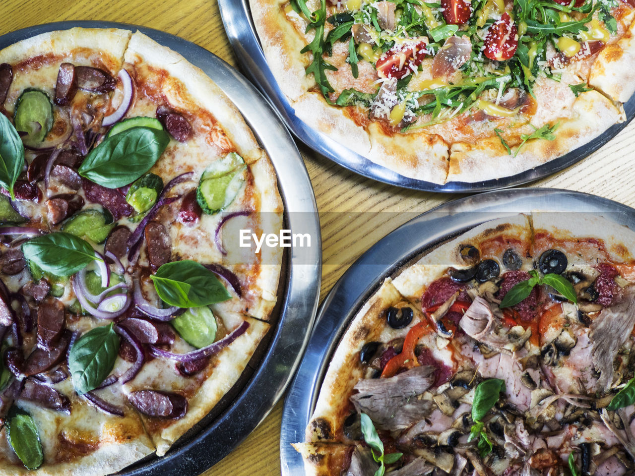 High angle view of pizzas served in plates on table