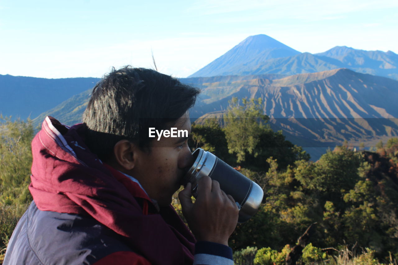 Man photographing against mountains