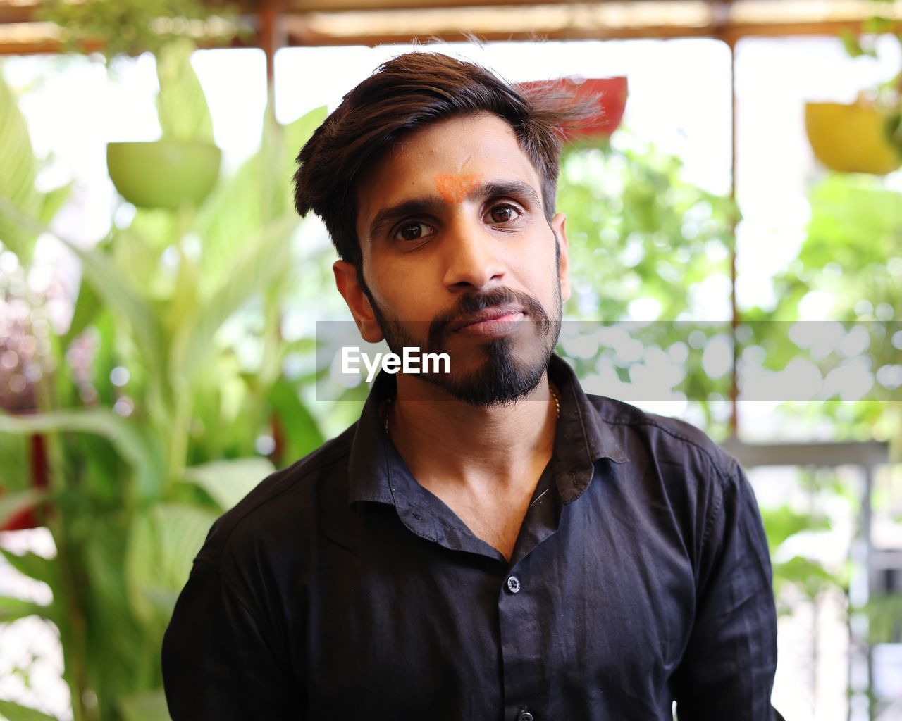one person, adult, beard, portrait, facial hair, men, person, young adult, headshot, nature, looking at camera, clothing, casual clothing, plant, front view, flower, lifestyles, looking, human face, day, outdoors, standing, spring, occupation, waist up, contemplation, emotion, serious, individuality, focus on foreground