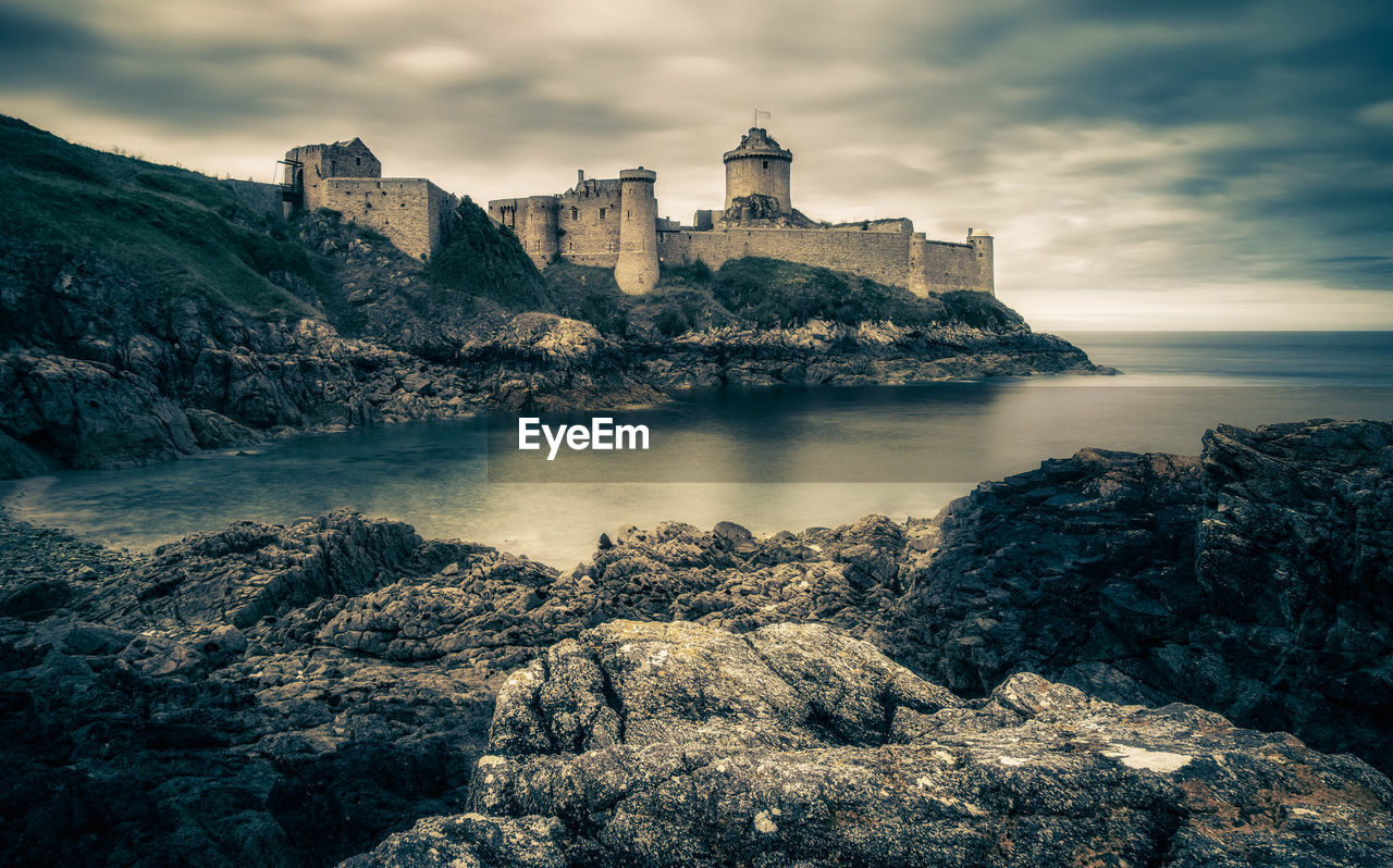 Scenic view of sea by buildings against sky