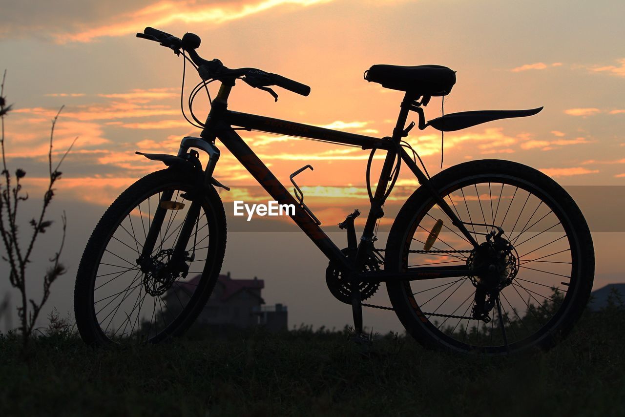 SILHOUETTE BICYCLE ON FIELD DURING SUNSET