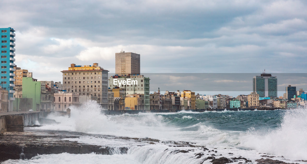 Scenic view of sea by buildings against sky