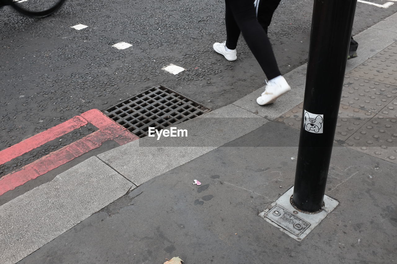 LOW SECTION OF PERSON STANDING ON ROAD