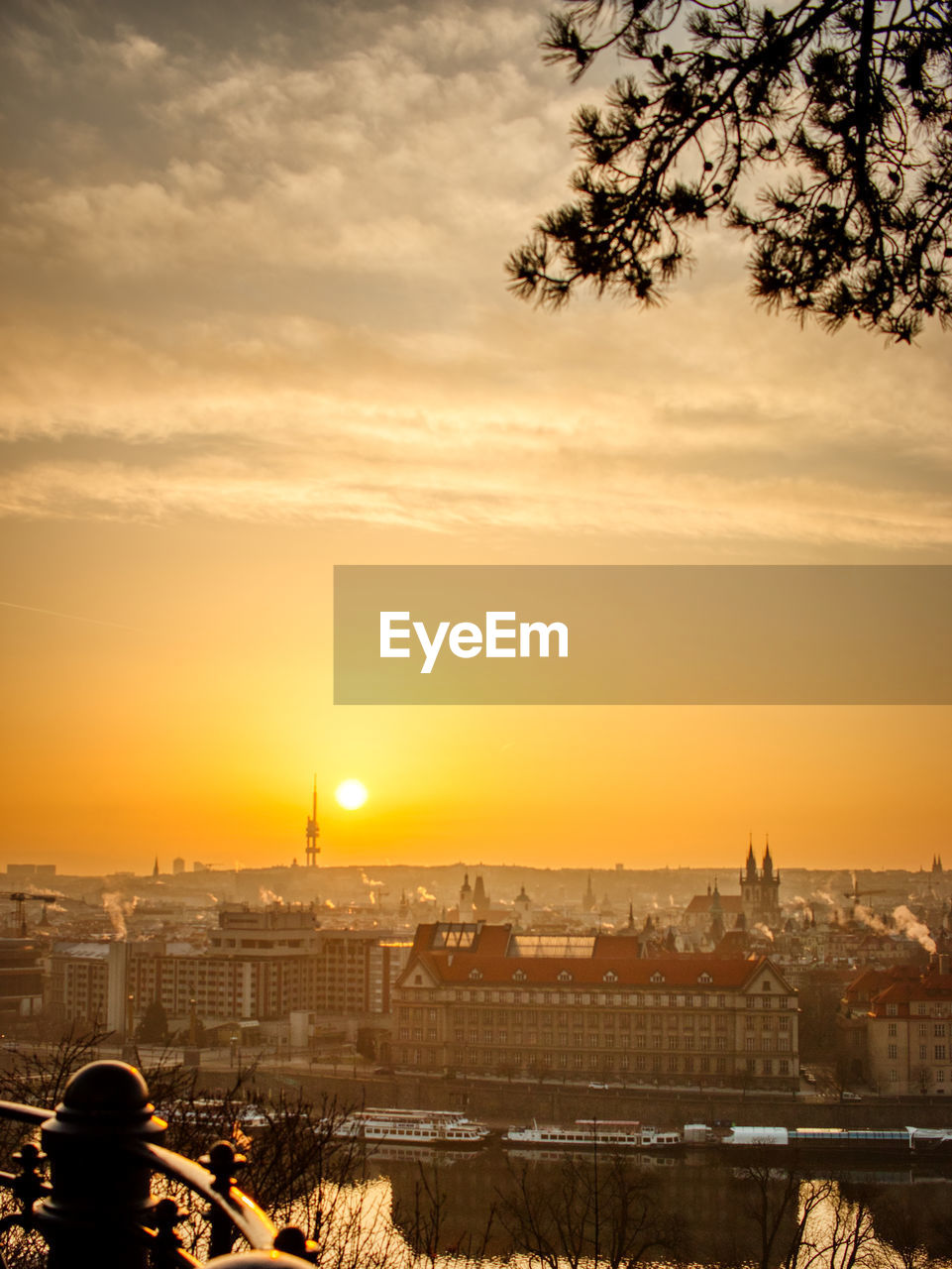 Prague tv tower at sunrise wirh roofs and birds flying