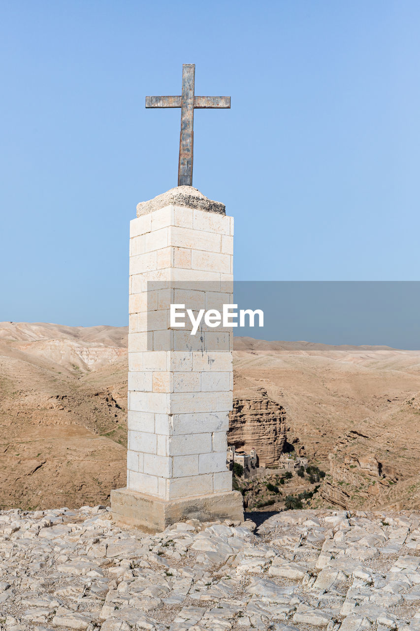 LOW ANGLE VIEW OF CROSS ON BEACH AGAINST CLEAR SKY