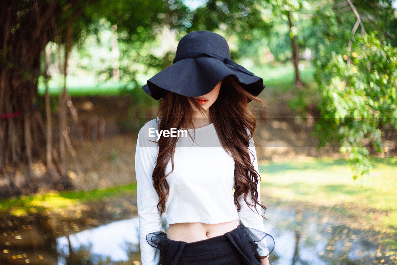 Woman wearing hat standing on land