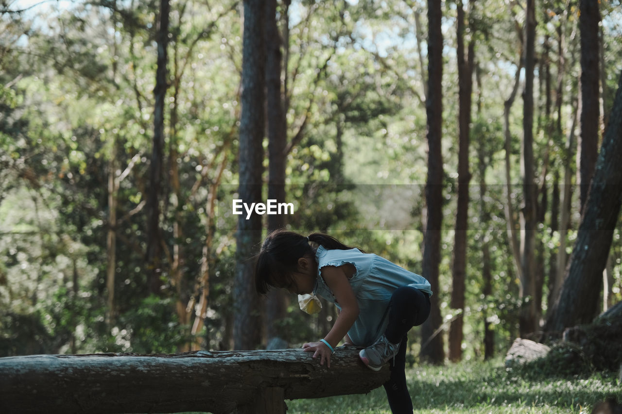 Side view of girl playing at forest