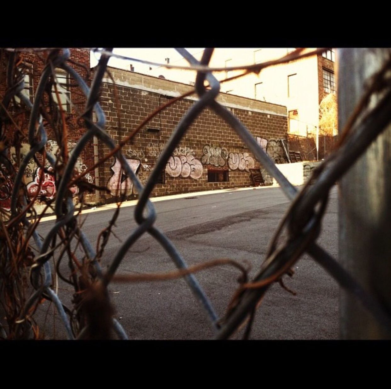 CLOSE-UP OF CHAINLINK FENCE IN CITY AGAINST SKY