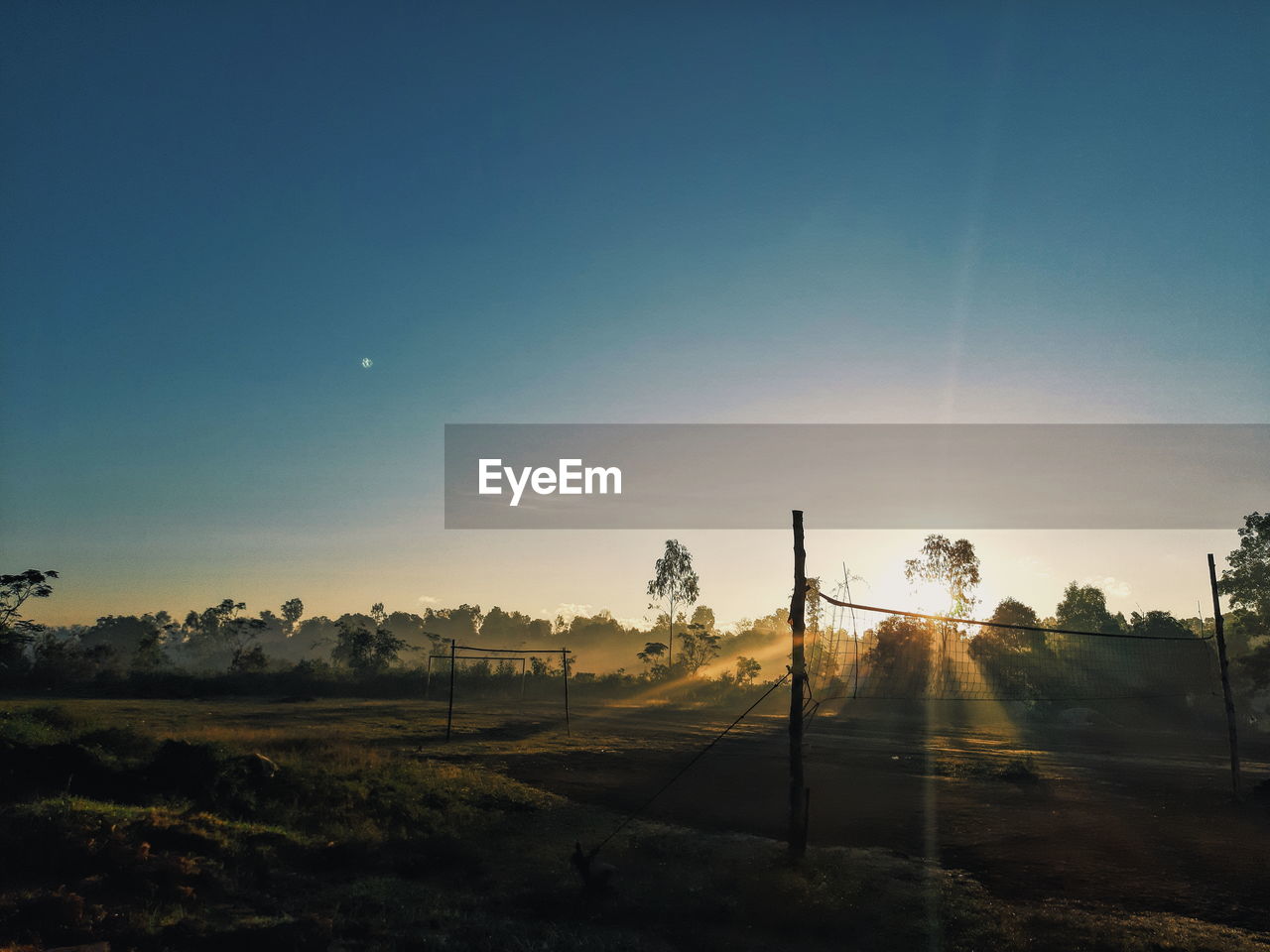 Scenic view of field against clear sky during sunset