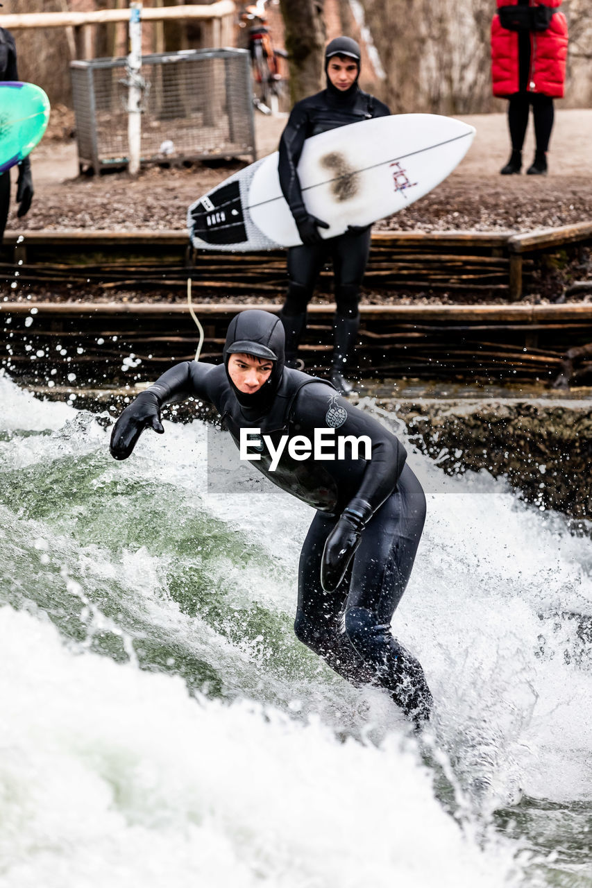 FULL LENGTH OF MAN SPLASHING WATER AT CAMERA