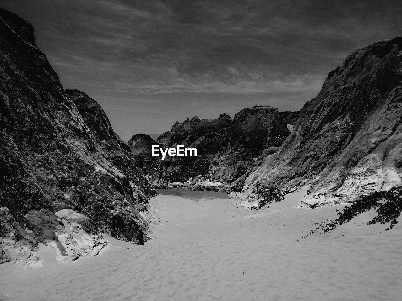 Snow covered land and mountains against sky