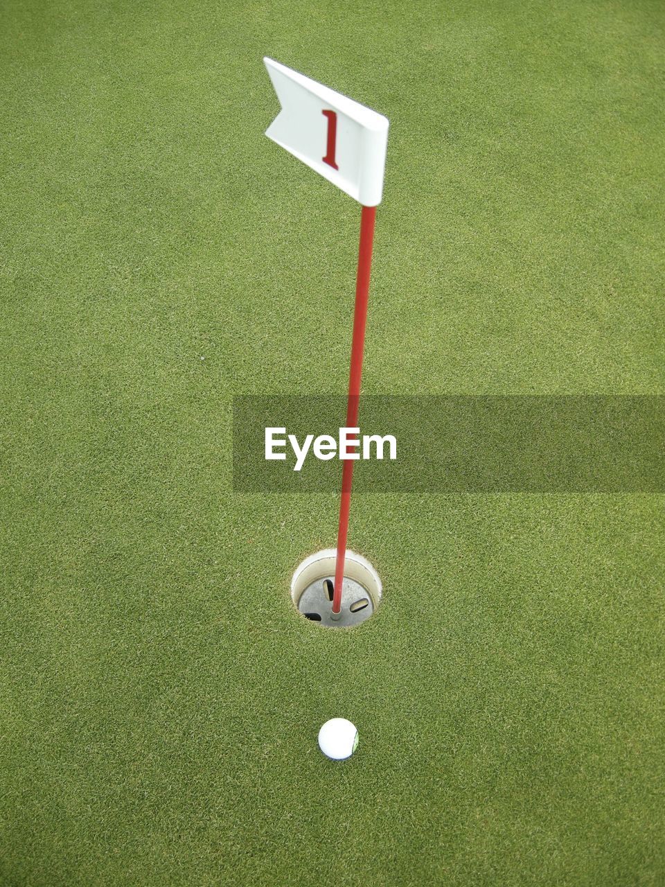 High angle view of golf ball by hole at course