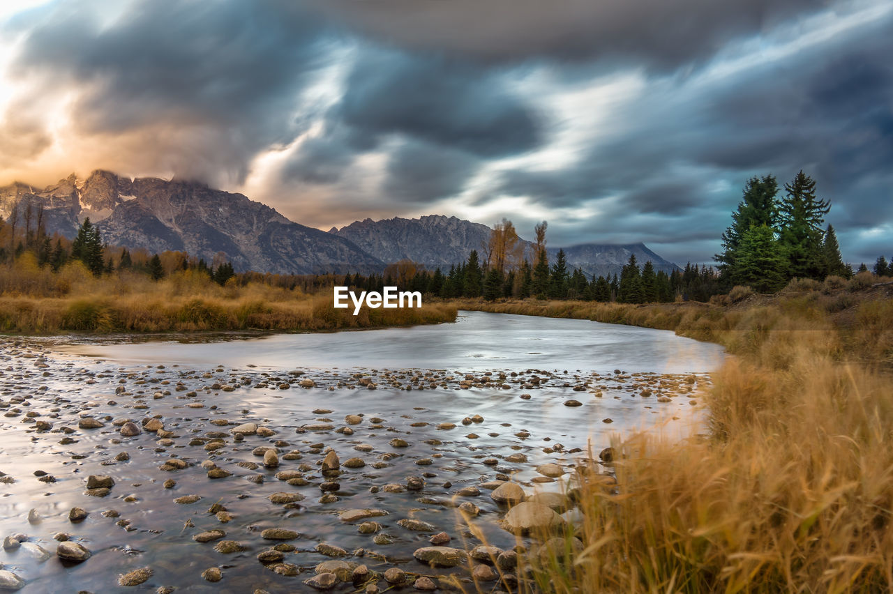 SCENIC VIEW OF LAKE BY MOUNTAIN AGAINST SKY