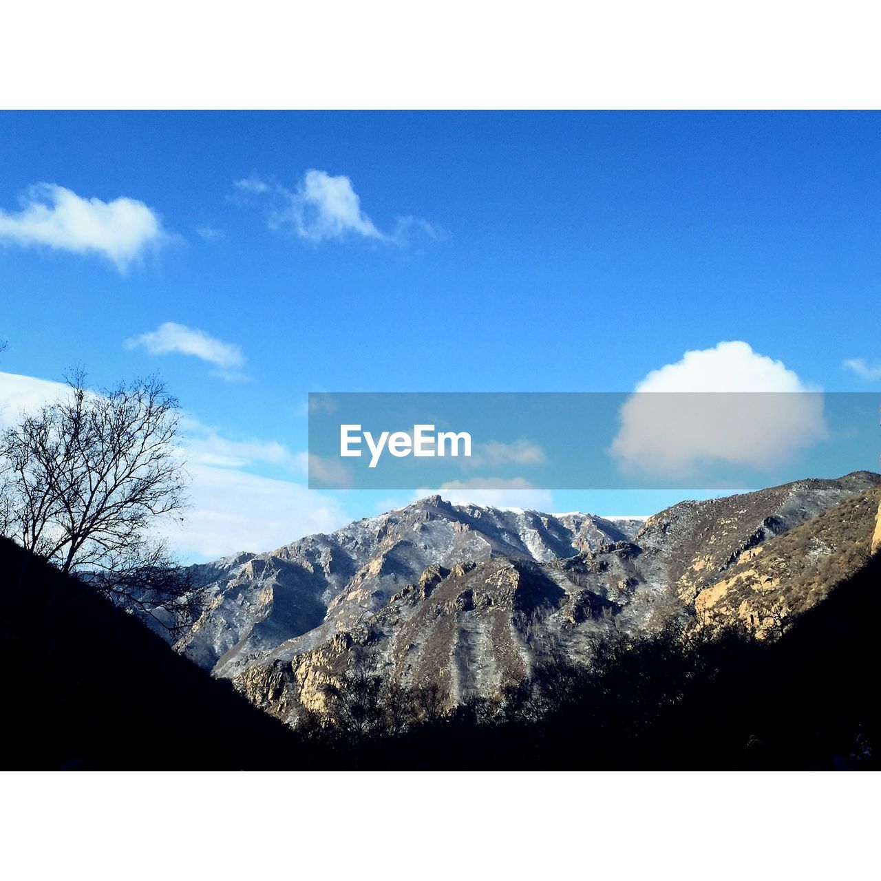 Scenic view of mountains against blue sky