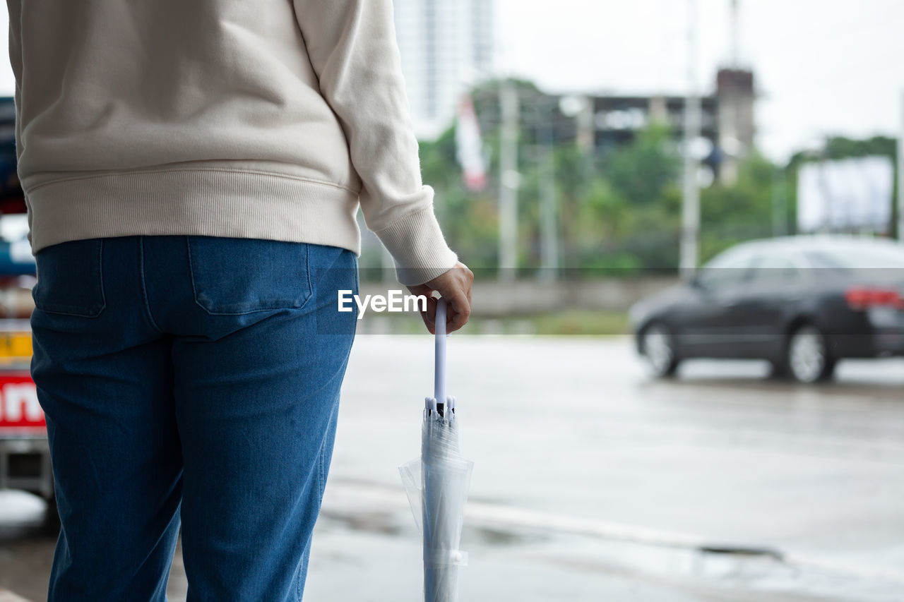 Midsection of woman standing on street