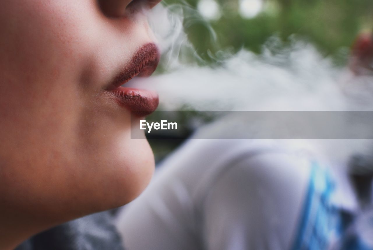 Close-up of woman exhaling smoke